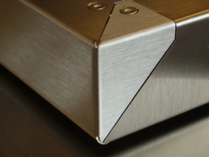 Brushed stainless enclosure corner with tight seams